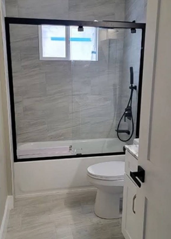 Bathroom Derjohn remodeled with new tile, glass shower door and fixtures